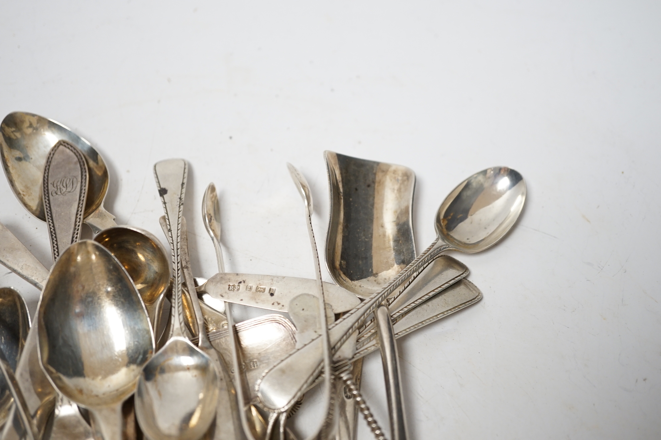 A small quantity of assorted 19th century and later silver flatware, two white metal spoons and a Victorian 'Rum' wine label, 18.2oz.